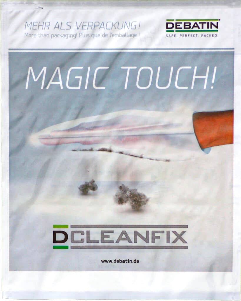 Cleanfix Promotional image for the CLEANFIX® bag with the slogan “MAGIC TOUCH!”. A hand uses the flat CLEANFIX surface to pick up lint. DEBATIN logo and the claim “More than packaging!” appear at the top.
