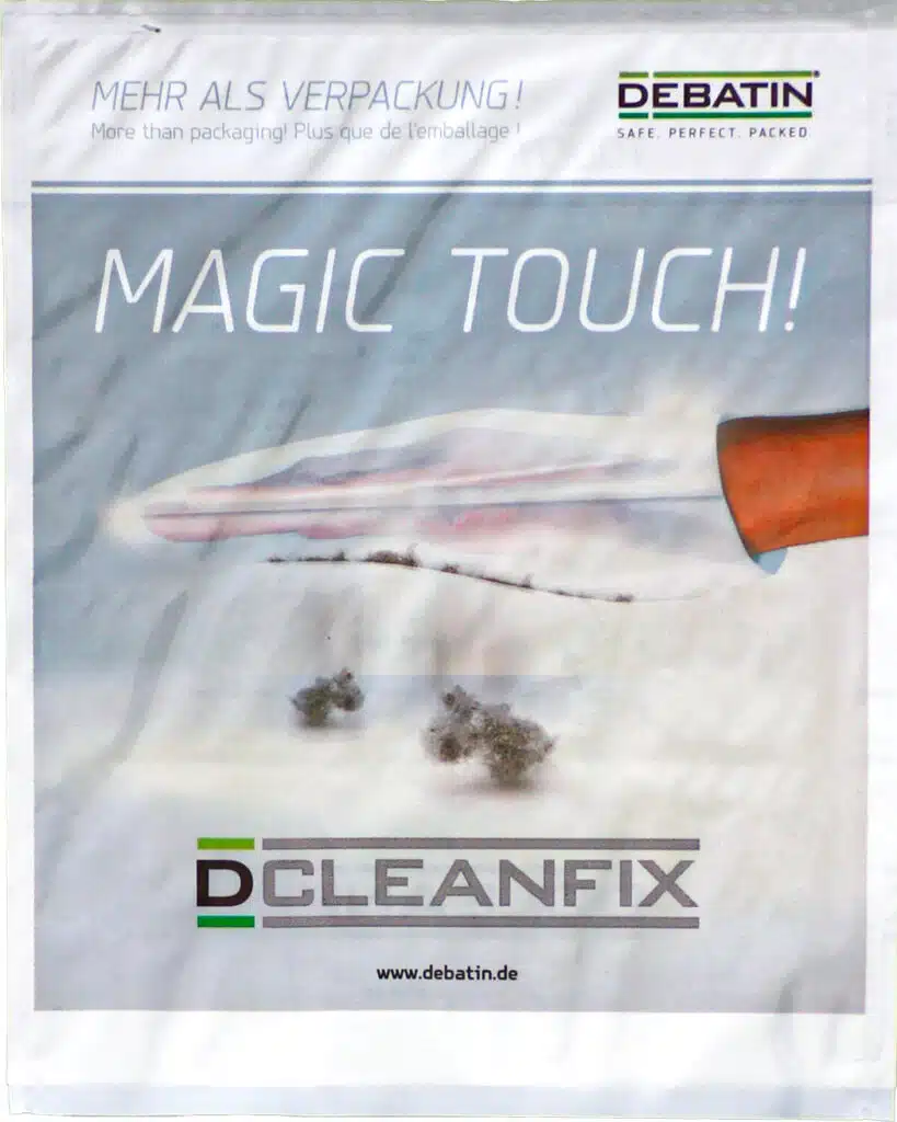 Cleanfix Promotional image for the CLEANFIX® bag with the slogan “MAGIC TOUCH!”. A hand uses the flat CLEANFIX surface to pick up lint. DEBATIN logo and the claim “More than packaging!” appear at the top.