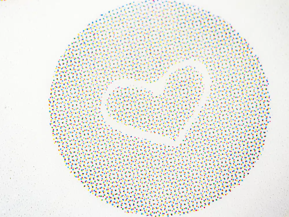 IMG_0107 Detailed close-up of a DEBATIN product, created using the DEBAPRINT flexographic printing process. The background features a circular grid of CMYK colour dots, with a heart-shaped cutout in the centre. The vibrant colours and precise dot arrangement highlight the exceptional print quality of DEBAPRINT.