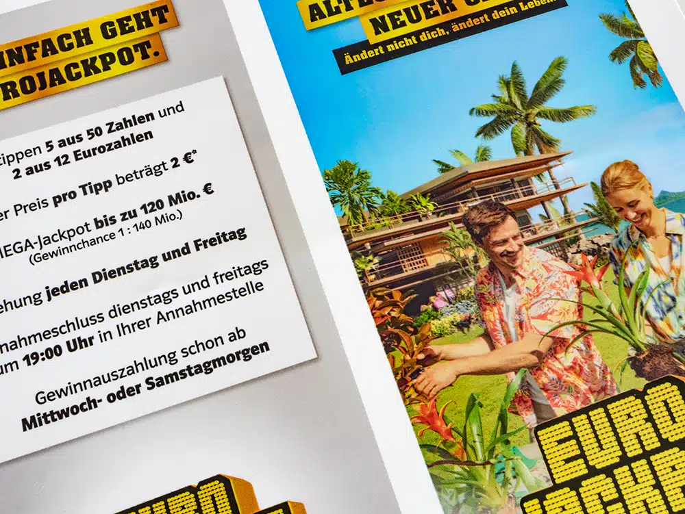 IMG_0126 Close-up of a DEBATIN print product manufactured using the DEBAPRINT flexographic printing process. Two Eurojackpot advertisements are visible: one featuring text with the jackpot details and the other a coloured image of a couple in a tropical paradise alongside a slogan meaning “Don’t change yourself, change your life”.