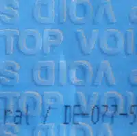DebaTAPE_web_blau Detailed view of a DEBATAPE security tape reacting to cold exposure. The surface of the sealing strip has changed under cold conditions, revealing a pattern or structure not present at normal temperatures, indicating tampering through cooling.
