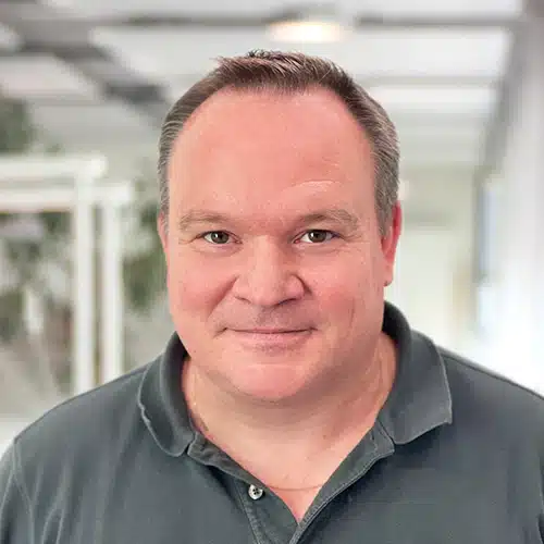 Portrait of Laurent Roser, a man with short dark hair and a friendly look. He wears a dark polo shirt. Laurent Roser works in Production Management at DEBATIN.