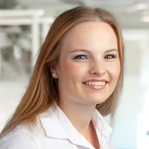 Portrait of Melina Hoffmann, a smiling woman with medium-length hair. She wears a white blouse and appears open and friendly. Melina Hoffmann is employed at DEBATIN.