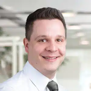 Portrait of Michael Hoffmann, a friendly-looking man with short brown hair. He wears a white shirt and a dark tie. Michael Hoffmann is Sales Consultant / Customer Service at DEBATIN.