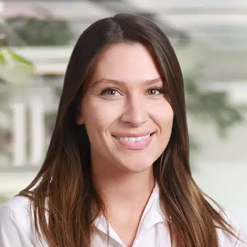 Close-up of Vanessa Dittrich, a smiling woman with long dark hair wearing a white shirt. She works as Sales Consultant / Customer Service at Debatin.